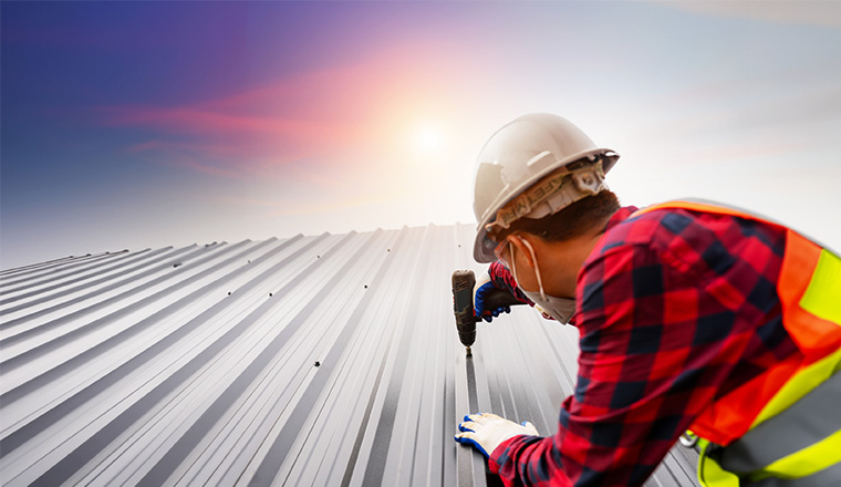Man in high vis working on a roof